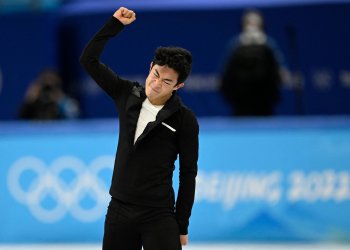 Nathan Chen fist pumps the air after a record-breaking short program at the Olympic Winter Games Beijing 2022.