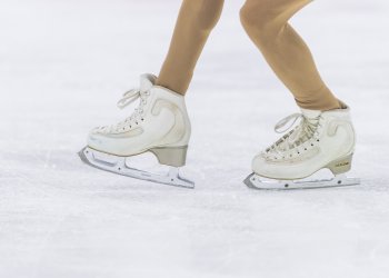 close up of the ice skates of a figure skater