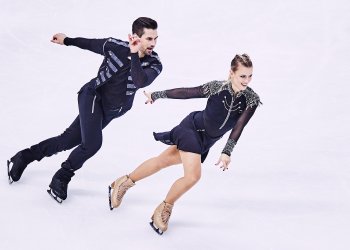Madison Hubbell and Zachary Donohue in black leather costumes on the ice.