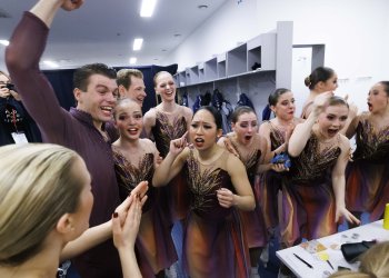 The Haydenettes wearing purple costumes celebrate, with captain Stephen Murray in center doing a fist bump