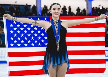 Elyce Lin-Gracey holds the American flag after earning the bronze medal at the 2025 World Junior Championships.