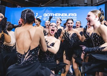 Dressed in black, Teams Elite celebrates their World gold medal in the kiss and cry