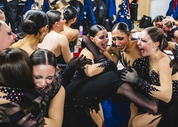 Teams Elite, dressed in black, embrace and celebrate their historic World title. 