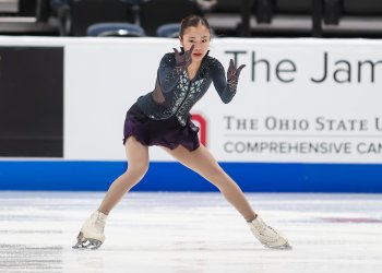 Logan Higase-Chen, dressed in a black costume with black gloves, tells a story with hands and fingers extended