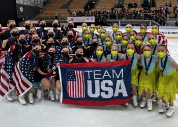 Teams Elite and Skyliners Junior pose together with U.S. flags at World Junior Synchronized Skating Championships