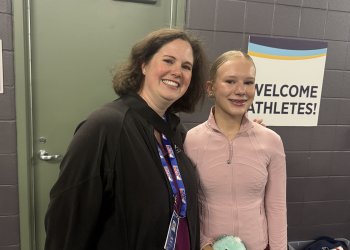 Coach Jessica Stratton, dressed in black, stands backstage with student Charlotte Anderson, dressed in a peach-colored costume.