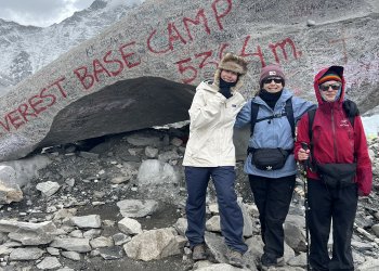 Alysa Liu, dressed in a white winter coat and cap, stands with friends at Mt. Everest Base Camp.