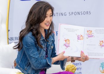 Olympic champion Kristi Yamaguchi holds a book open as she reads to children. 