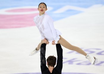 Audrey Lu is lifted over Mitrofanov's head as she looks towards the camera