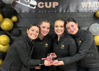 Members of the Adrian College Figure Skating Team pose with their trophy. 