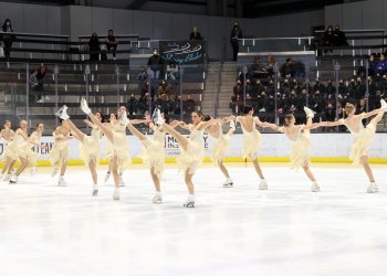The Northernettes, in yellow dresses, in two lines doing high kicks.