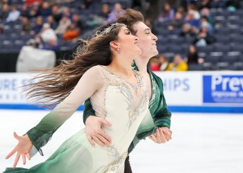 Dressed in green and white, Elliana Peal and Ethan Peal glide side by side with his arm around her waist.