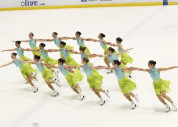 Skyliners Junior holding arms in three rows in teal and lime green dresses.