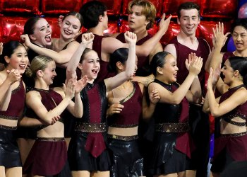 Sophie Joline von Felten, front row, arms extended up, celebrates Act 1 of Boston's victory at National Showcase.