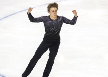 William Annis, wearing dark colors, raises his hand to the air during his program.