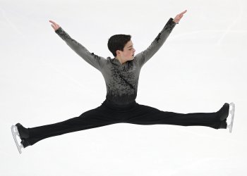 Ben Klein does a split jump at a competition.