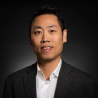 Headshot of William Tran. William is an Asian man with short black hair wearing a white buttondown shirt with a black blazer over top