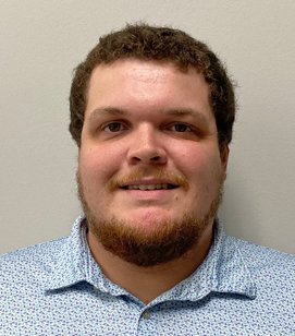 Headshot of Christian Suero. He is a white man with short brown hair and a heard. He is wearing a blue collared shirt. 